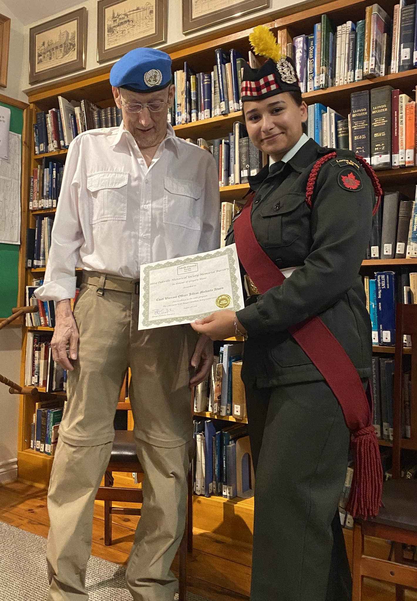 Photo of OHS volunteer Greg Munz and cadet Chief Warrant Officer Jillian Alwyn holding a certificate