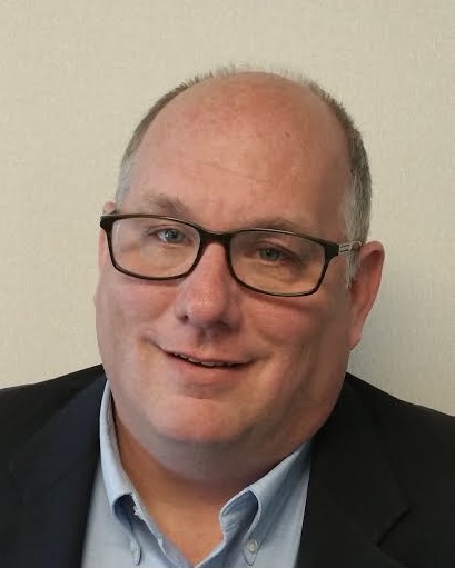 Head shot of bald man with glasses