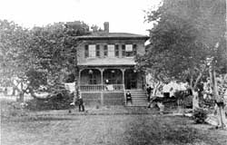 Black and white old photo of two story house