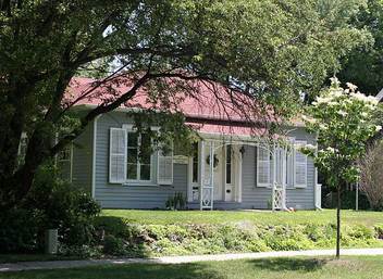 Color photo of one story house in summer