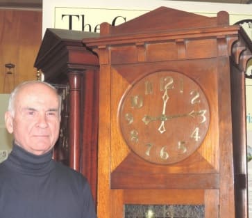 Photo of Alan Symons in front of an antique clock