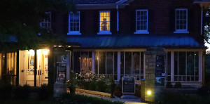 Ghostly figure in window of second floor house in the evening