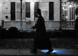 Ghostly figure walks by an old white house