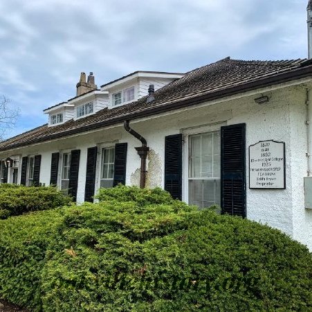 Old white house with plaque near front door