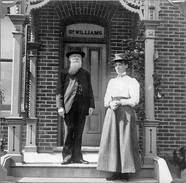 Vintage photo of Man and woman in front of entrance to brick building